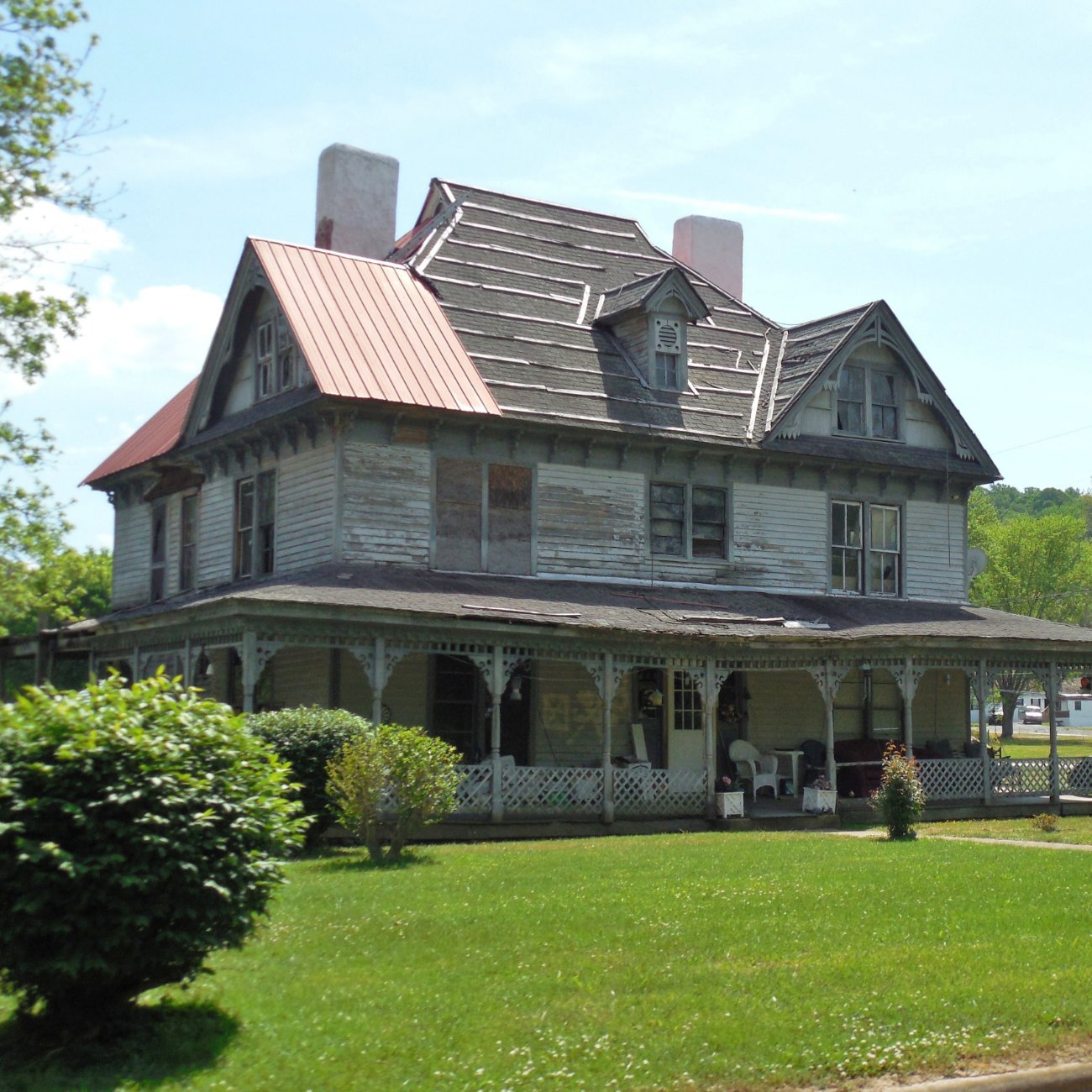 An older home with peeling paint and a worn roof
